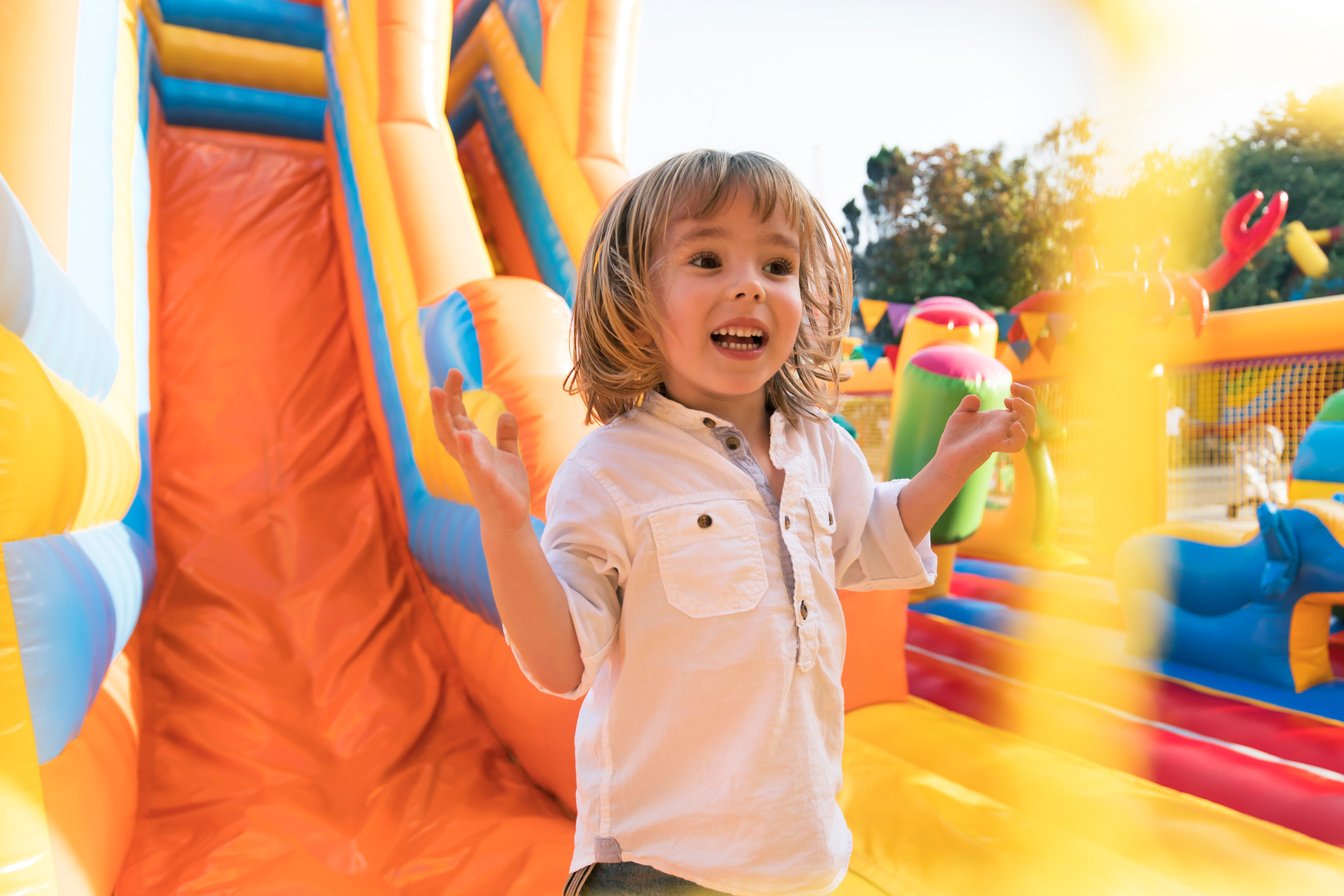 Little kid having fun in inflatable castle playground